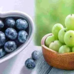 Fresh blueberries and sliced amla fruit placed side by side