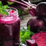 Beetroot juice in glass with raw beets for better hair health