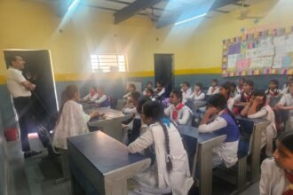 Assam Police officers conducting a cybercrime awareness session in a semi-urban college classroom with students attending.