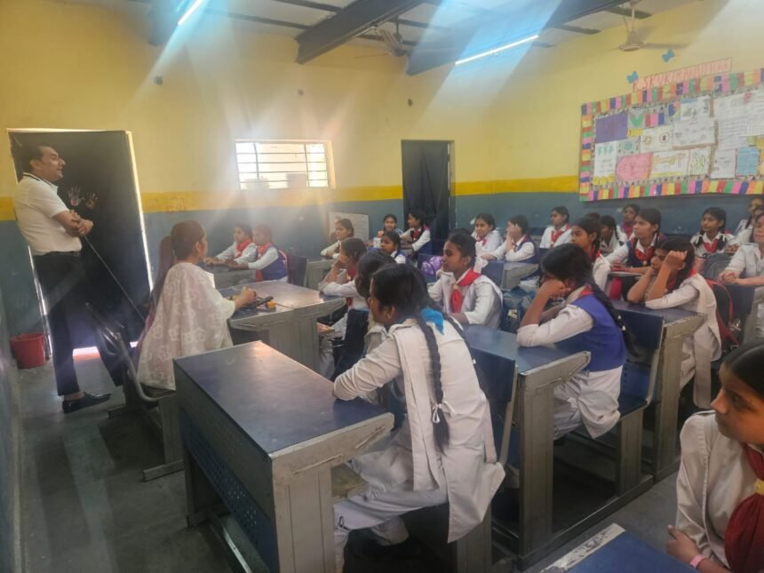 Assam Police officers conducting a cybercrime awareness session in a semi-urban college classroom with students attending.