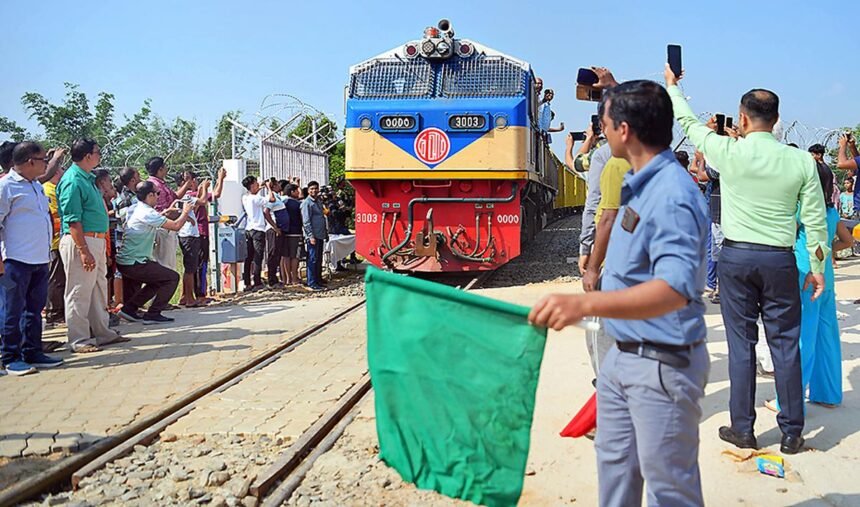 Train undergoing trial run on Agartala-Akhaura international railway line with engineers monitoring safety systems and track performance.