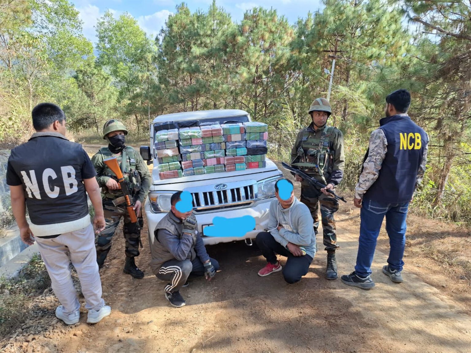 Security personnel display seized narcotics recovered during a coordinated border operation that intercepted a suspected cross-border drug shipment exceeding 200 kilograms.