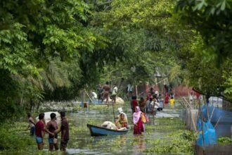 Floodwaters completely submerge villages in Charaideo district as homes, roads, and agricultural fields remain inundated during Assam's ongoing monsoon flood crisis.