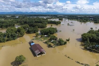 Floodwaters from the overflowing Brahmaputra River inundate residential areas in Jorhat as thousands of residents evacuate following widespread monsoon flooding.