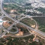 A proposed ring road infrastructure project around Guwahati showing modern highways and urban connectivity improvements supported by a government mitigation plan.