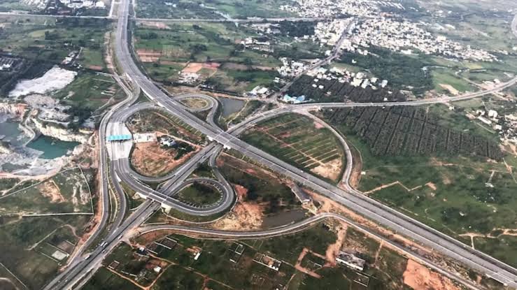 A proposed ring road infrastructure project around Guwahati showing modern highways and urban connectivity improvements supported by a government mitigation plan.