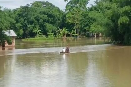 Floodwaters inundate homes and roads across Sivasagar district as residents navigate submerged neighborhoods during Assam's ongoing flood emergency affecting more than 2 lakh people.