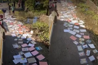 Youth volunteers in Sivasagar spread flood-damaged school textbooks along roadsides to dry and salvage educational materials.