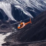 An emergency rescue helicopter prepares for a medical evacuation mission in a mountainous region where road access has been disrupted by severe monsoon conditions.